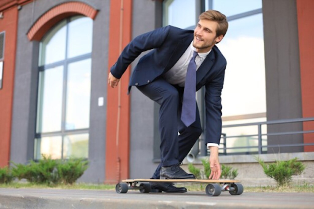 confident young businessman in business suit on skateboard 