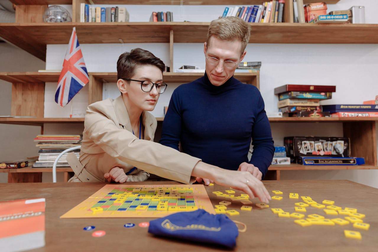 A man and a woman plying scrabble words for learning