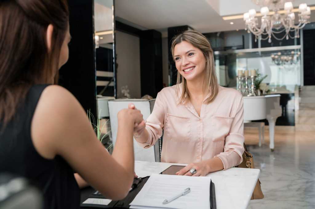 two young businesswomen having meeting and shaking hand
